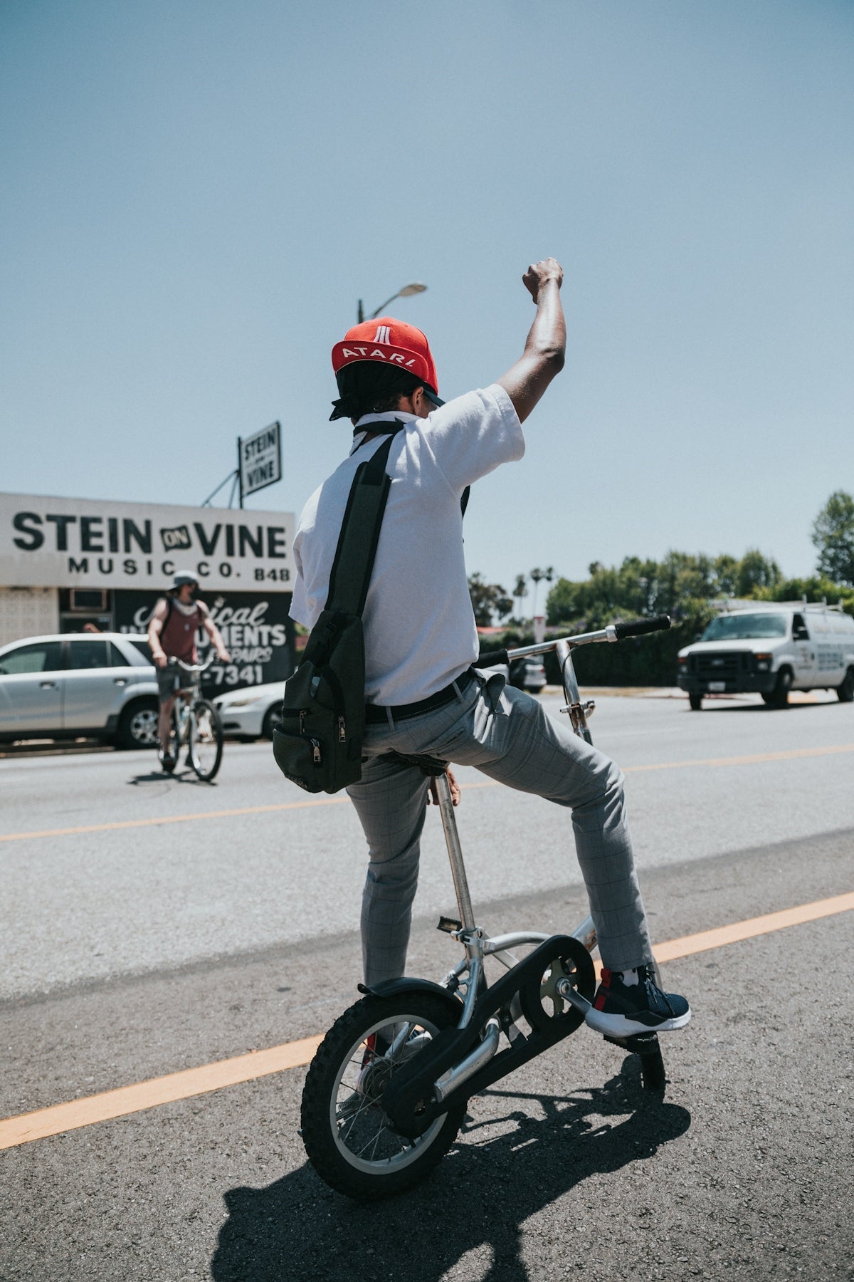 man in white long sleeve shirt and red helmet riding on black bicycle during daytime