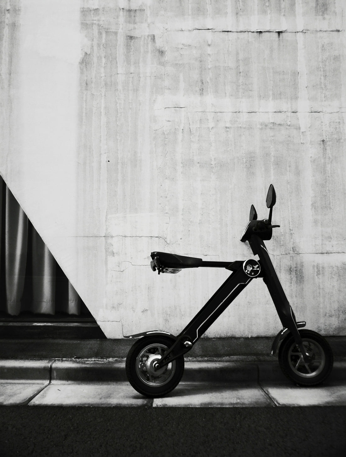 black and gray bicycle beside white wall