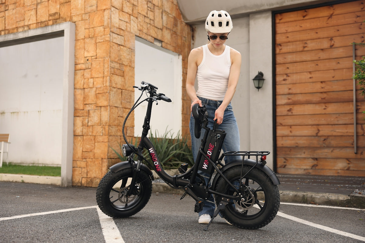 A woman standing next to a black bike in a parking lot