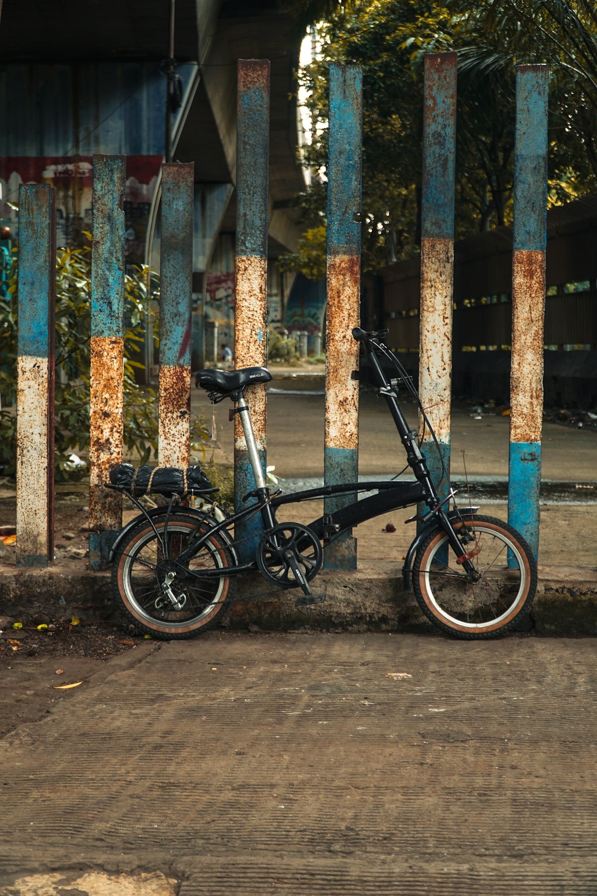 A bicycle parked next to a blue and white fence