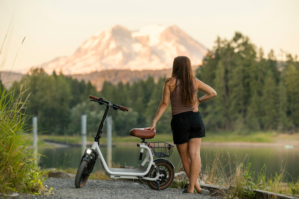 Woman enjoys view with scooter and mountain