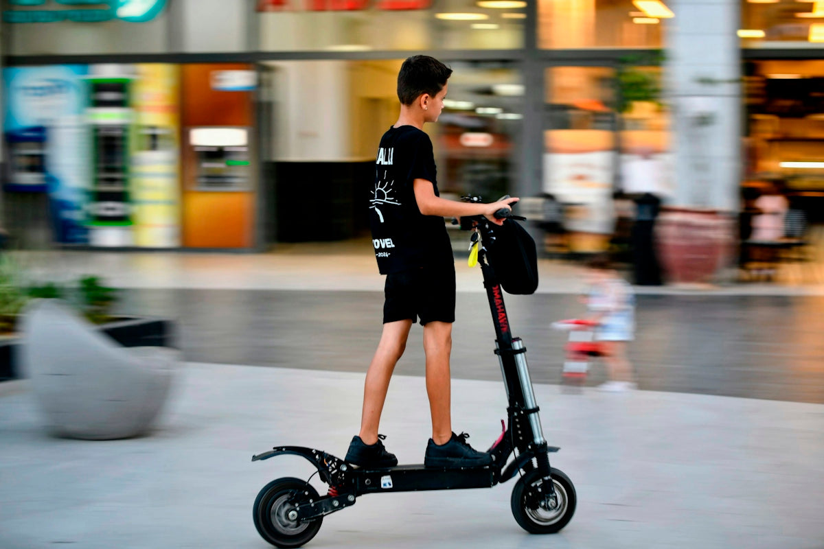 Young boy riding an electric scooter outdoors