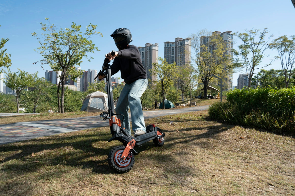 Person riding an electric scooter on a grassy hill